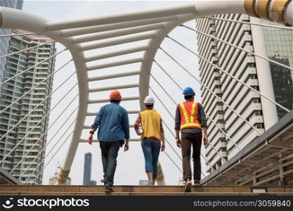 engineer team walking on stair of skywalk of city. They discuss or talk about planning project progress to successful construction business property estate investment