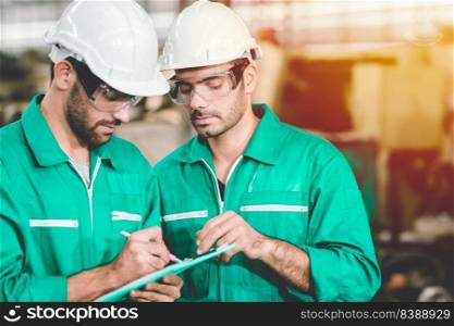 Engineer teamwork cooperate with worker to checking factory machine for safety and talking together.green industry man.