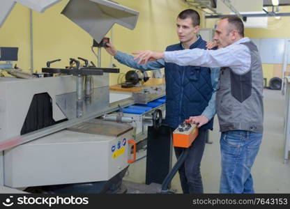 engineer training apprentices on cnc machine