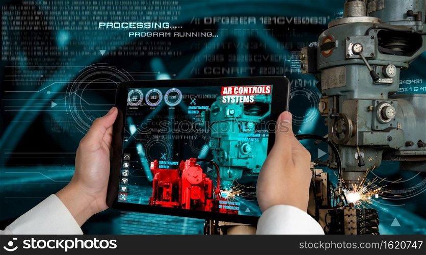 Engineer use augmented reality software in smart factory production line with automated application . Futuristic machinery in working in concept of Industry 4.0 or 4th industrial revolution.. Engineer use augmented reality software in smart factory production line