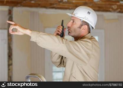 engineer using walkie talkie on construction site