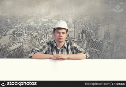 Engineer with banner. Young builder man with white blank banner. Place for text