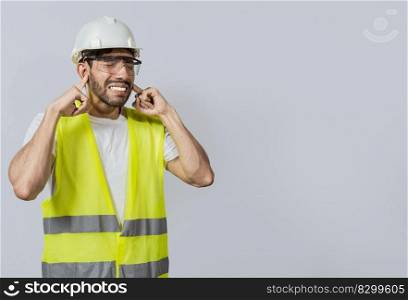 Engineer with ear pain isolated, Young engineer covering his ears isolated, Builder man with ear pain, Concept of engineer covering his ears with pain expression.