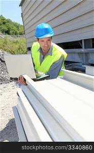 Engineer with laptop computer on building site