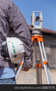 Engineer with tacheometer or theodolite for survey line columns for the construction of buildings