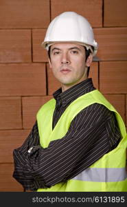 engineer with white hat with a brick wall as background