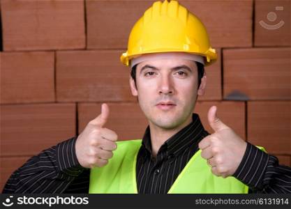 engineer with yellow hat and a brick wall as background