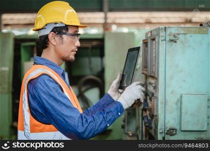 Engineer worker program setup CNC machine in metal industry factory with tablet technology.