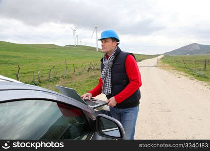 Engineer working on laptop computer in wind turbines field