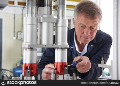 Engineer Working On Machine In Factory