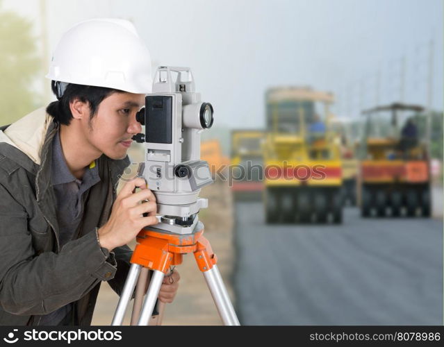 engineer working with survey equipment theodolite with road under construction background