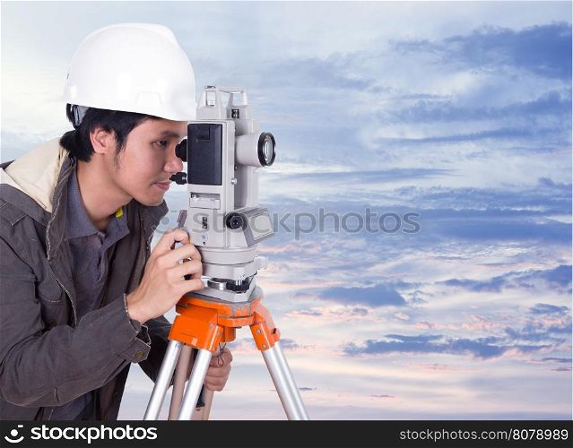 engineer working with survey equipment theodolite with sky at sunset