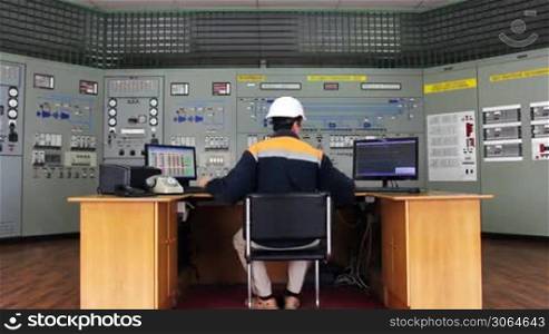 engineer works at table in front of panel process control