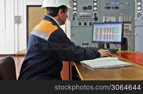 engineer works on computer sitting at desk, close-up