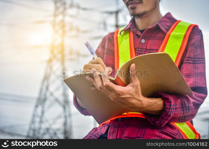 Engineer writing on notebook at work