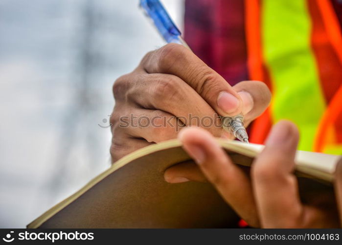 Engineer writing on notebook at work