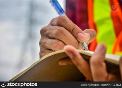 Engineer writing on notebook at work
