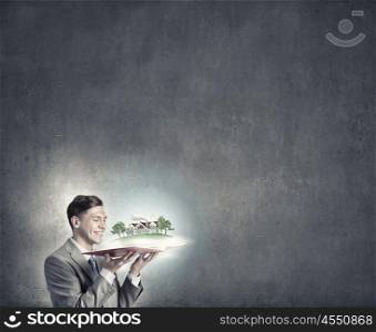 Engineering and construction. Businessman holding opened book with construction model on pages