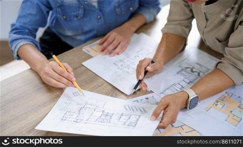 Engineering construction concept, Two female engineers is discussing blueprint of building together.