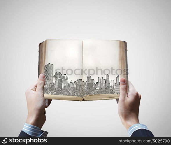 Engineering education. Male hands holding opened book with construction sketches