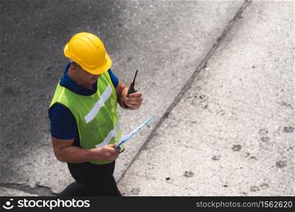 engineering foreman control wearing helmet working at container terminal, cargo freight ship for import export