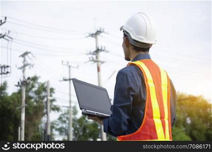 Engineering Holding Notebook inspects the wires on the electrical pole.