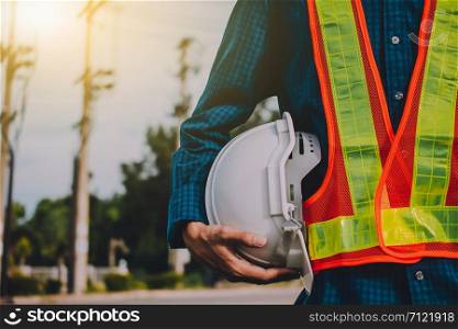 Engineering holds white safety hats and electric pole background