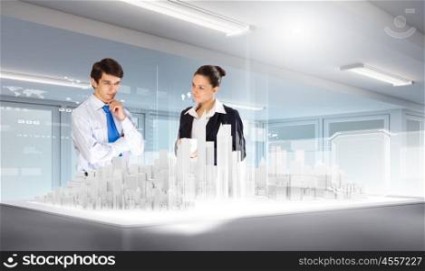 Engineering industry. Businessman and businesswoman discussing construction model of project