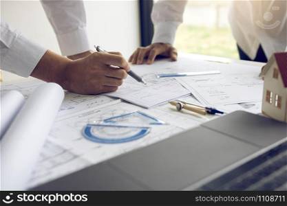 Engineering man showing blueprint detail for people buying house.