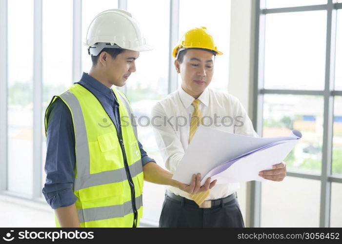 Engineering people are analytics construction plans with blueprint in office .. Engineering people are analytics construction plans with blueprint in office