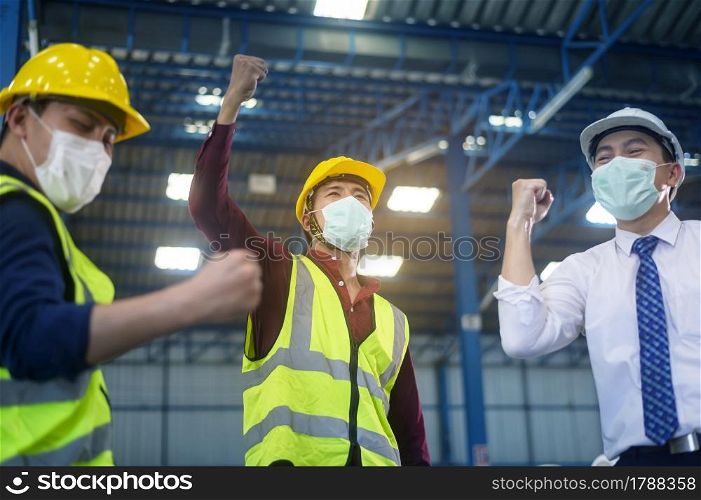 Engineering people are wearing face mask happy in modern factory , industrial successful and teamwork concept
