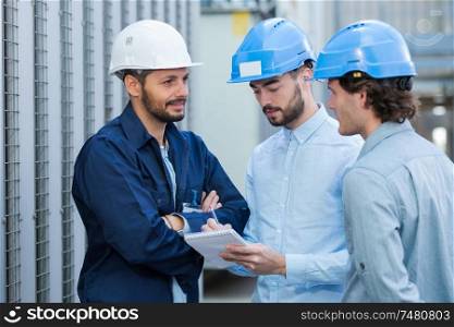 engineers during conversation outside factory