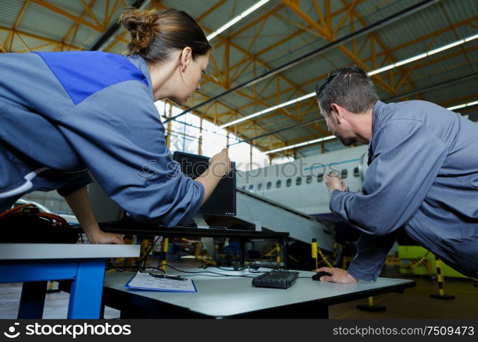 engineers in discussion in commercial airline hangar