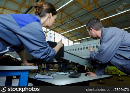 engineers in discussion in commercial airline hangar