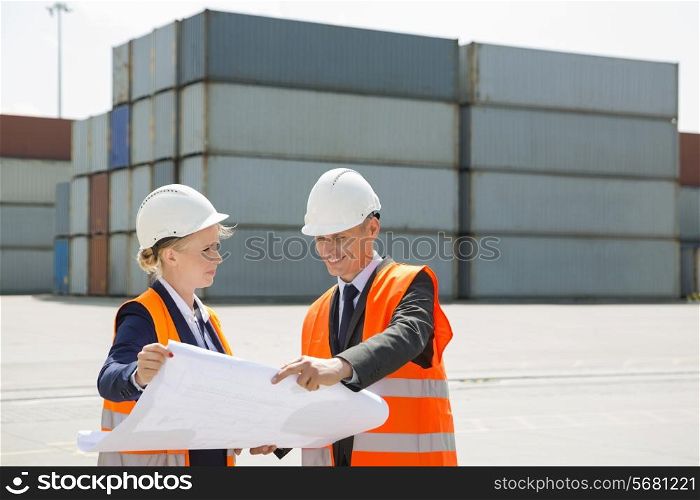 Engineers looking at blueprint in shipping yard