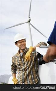 Engineers near wind turbine at wind farm