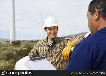 Engineers near wind turbines at wind farm