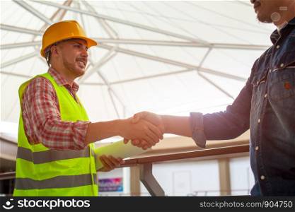 Engineers shake hands with businessman after success day and celebrate success.