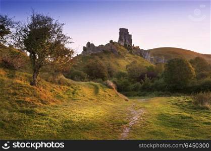 England, Dorset, Corfe. A view toward Corfe Castle.. Old medieval castle ruins in Summer sunrise landscape image