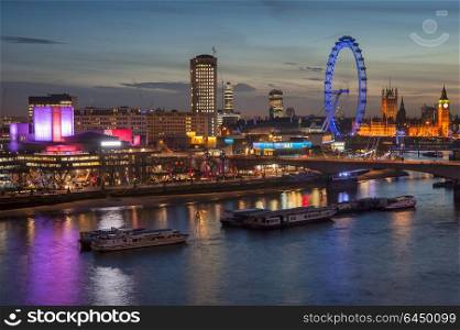 England, London, London. The London skyline at night including Parliament with the London Eye and the South Bank.. Landscape image of the London skyline at night looking along the River Thames