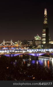 England, London, The Shard. The Shard in London towers over various bridges and tall buildings.. Landscape image of the London skyline at night looking along the River Thames