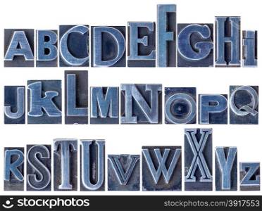 English alphabet - a collage of 26 isolated letters in letterpress metal type printing blocks, a variety of mixed fonts stained by blue ink