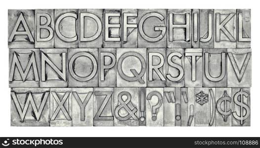 English alphabet, dollar, cent and punctuation signs in vintage metal type, black and white image with platinum toning