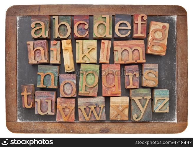 English alphabet in vintage letterpress wood type on an old slate blackboard