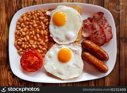 English breakfast with two eggs sausage beans bacon and grilled tomato