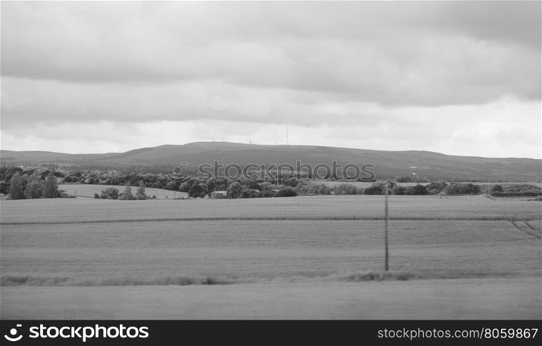 English country landscape. English countryside seen from a train near Preston, with selective focus on the horizon and motion blur on the foreground in black and white