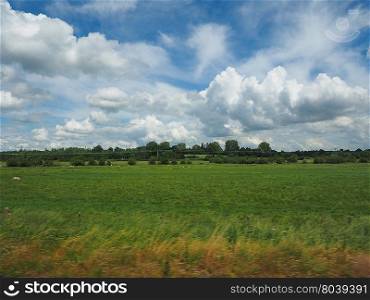 English country landscape. English countryside seen from a train to London, with selective focus on the horizon and motion blur on the foreground