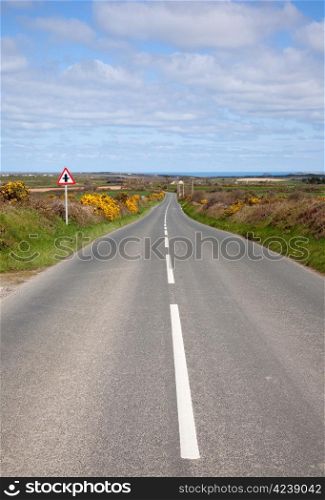 English country road with the sea on the horizon.