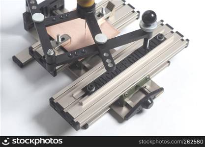 Engraving device pantograph with CNC engraver with letterpress alphabet on a white background. Engraving device pantograph with CNC engraver with letterpress alphabet