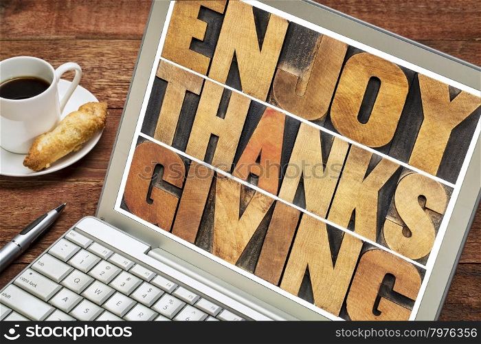 Enjoy Thanksgiving - word abstract in vintage letterpress wood type blocks on a laptop screen
